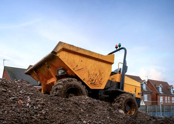 mini gelb dumper mit rollbalken blinkt lichter und kipper vorne eimer auf der baustelle - agricultural equipment flash stock-fotos und bilder