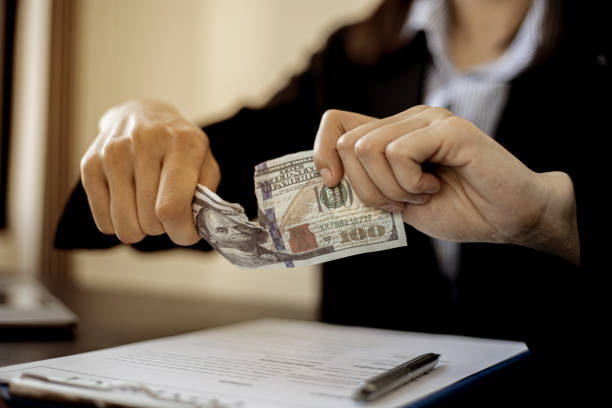 istock Businessmen are ripping off the dollar bills. 1300828498