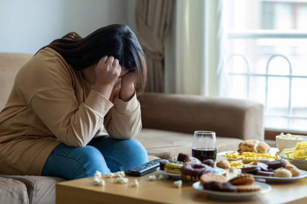 不幸なストレスの女性 - 不健康な食事 ストックフォトと画像
