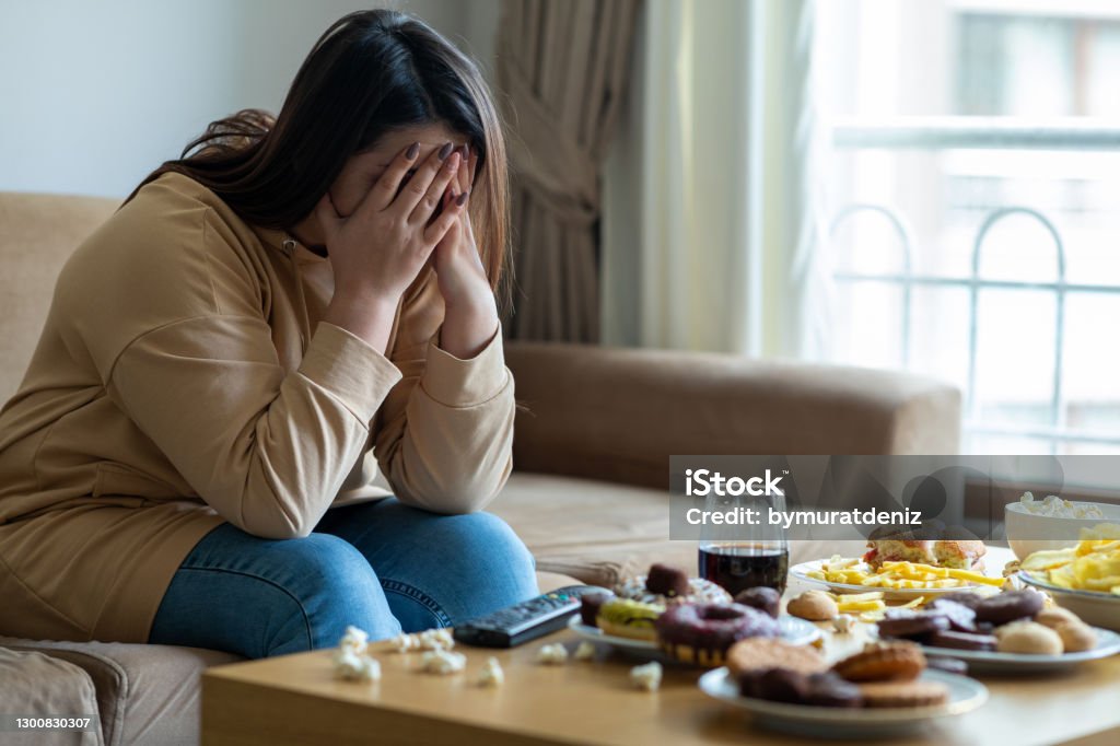 Unhappy stressed woman Over Eating Stock Photo