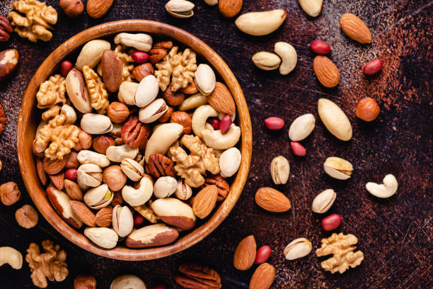 istock Various Nuts in wooden bowls 1300830818