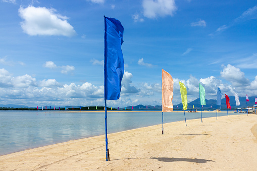 Colorful flags fluttering in the wind on the sandy beach to the Philippines. Motion blur