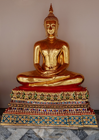 Small golden Buddha statue in lotus position.