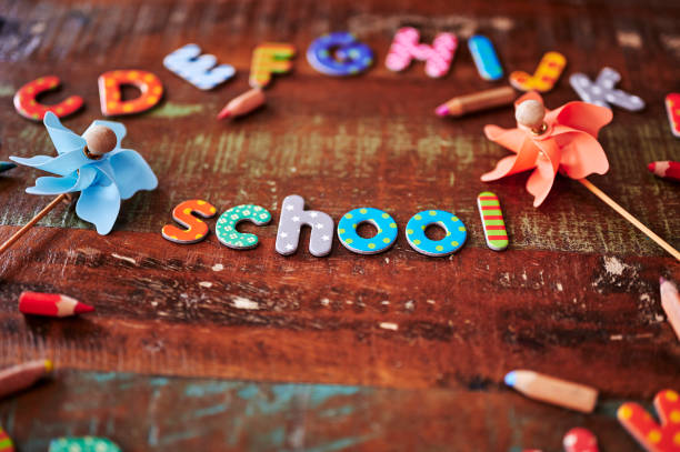 istock Auburn wooden table with different colorful letters. 1300835555
