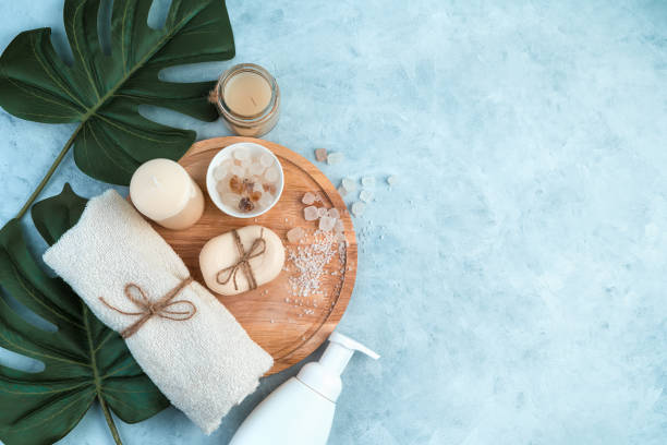 body care products on a light blue background with tropical leaves - tropical spa imagens e fotografias de stock