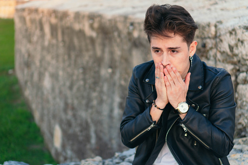 Stressed man standing in the city feeling anxiety