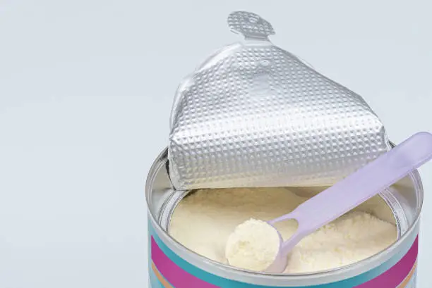 Photo of Infant formula in spoon. High angle view of baby formula and spoon in can