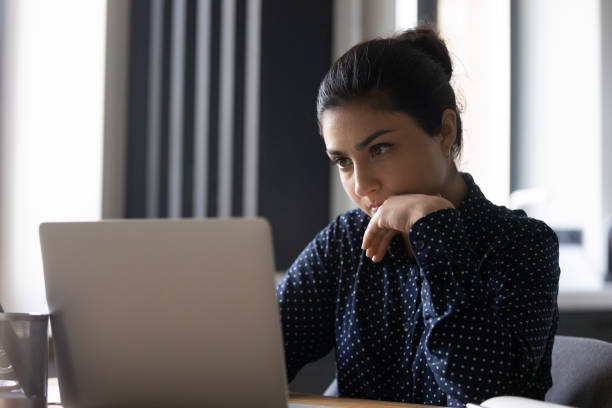 istock Pensive young Indian woman work on laptop 1300836686
