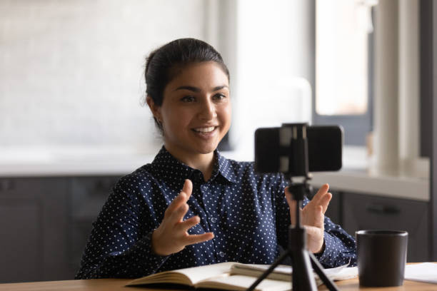 istock Young Indian female tutor record video on smartphone 1300836699
