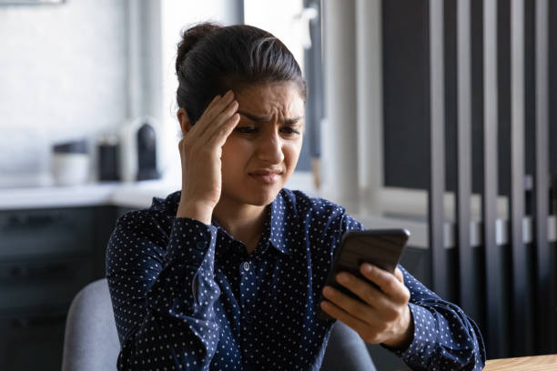 istock Unhappy Indian woman distressed with problems on smartphone 1300836771