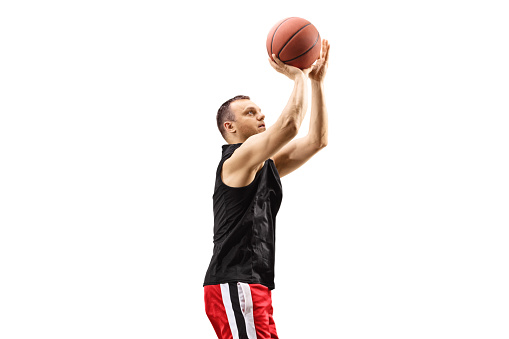 Basketball player shooting a ball isolated on white background