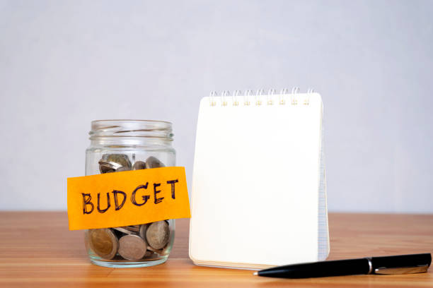 istock Personal budget, financial concept. Mason jar with coins inside, written budget 1300839876