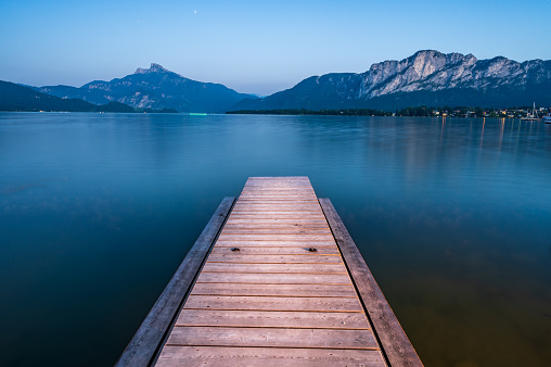 Wooden jetty at lake Mondsee near Salzburg during blue hour with stars