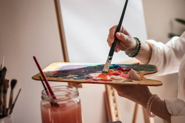 Art painter mixing acrylic colors on palette Creative abstract painting. Woman mixing acrylic colors at palette and working on paintings. Artist holding paintbrush in her studio abstract oil painting for beginners stock pictures, royalty-free photos & images
