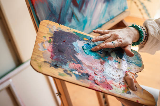 istock Art painter mixing colors on palette by hand 1300842895