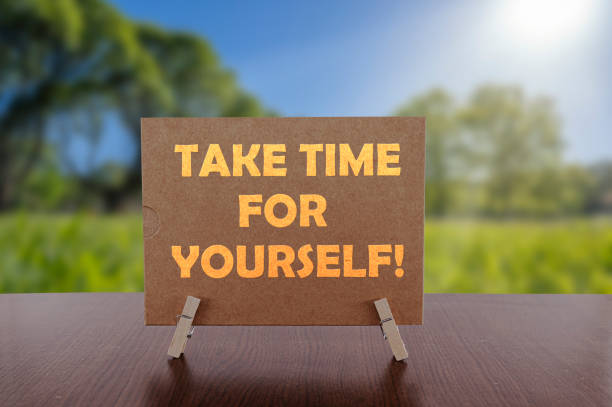 istock Take time for yourself text on card on the table with sunny green park background. 1300844412