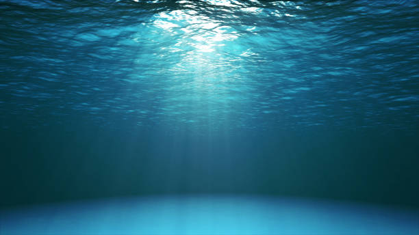Dark blue ocean surface seen from underwater Dark blue ocean surface seen from underwater. Abstract waves underwater and rays of sunlight shining through deep stock pictures, royalty-free photos & images