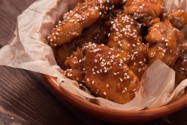 istock Chicken wings: honey, sesame, ginger. on a wooden table. 1300846783