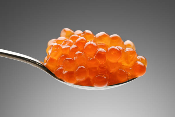 istock handful of red caviar in spoon on gray background 1300846885