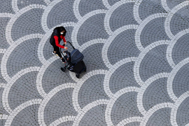 Mother Wearing Face Mask Walking Baby in Stroller