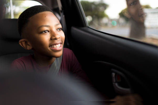 istock Close up happy young boy looking out from interior car 1300851418