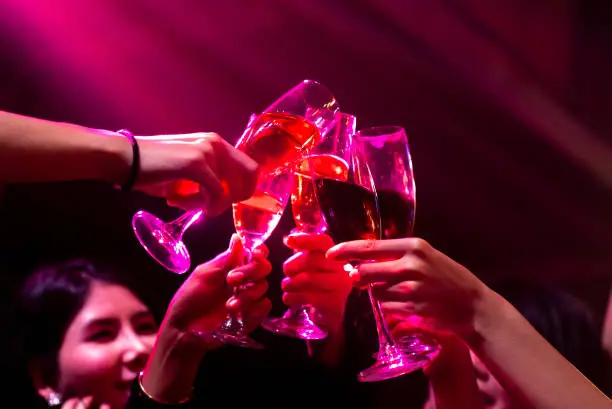 Photo of Group of people toast drinks at party in dancing club