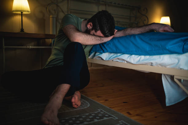 istock Depressed man sitting on the floor 1300851837
