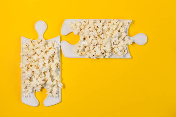 istock Puzzle dishes with popcorn on a yellow background. Text space 1300852832