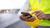 istock engineer working on his smartphone at the construction site 1300854990