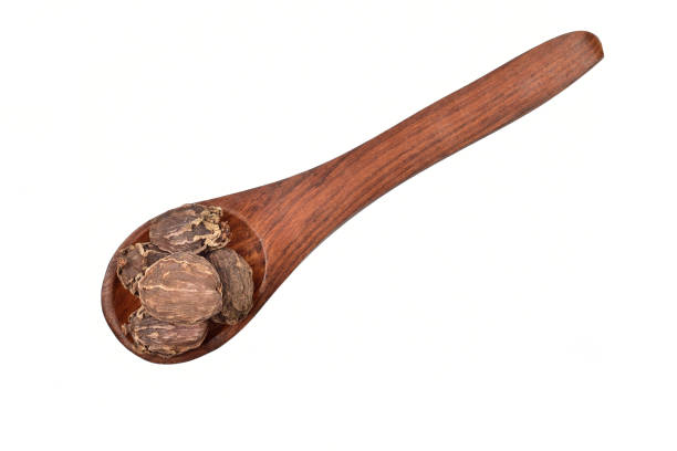 istock Black cardamom in wooden spoon isolated on white background with clipping path 1300855749