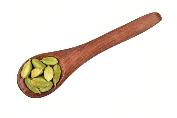 Cardamom in wooden spoon isolated on white background with clipping path, elaichi