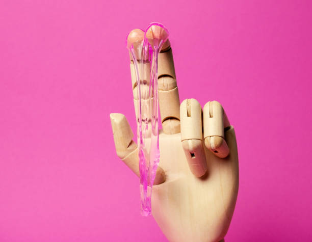 istock Wooden hand with dripping pink liquid paste pink background 1300856068