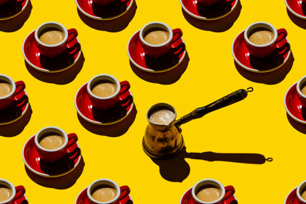 istock Espresso coffee in red cup and copper cezva on yellow background Pattern 1300858448