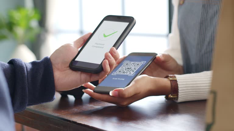 Customer using phone for payment at cafe restaurant, cashless QR code technology and money transfer concept