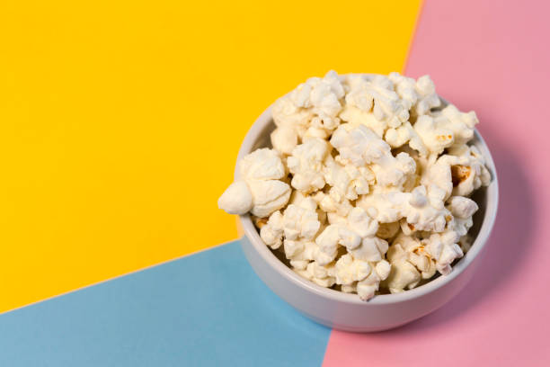 istock Bowl with popcorn on a yellow, blue and pink background 1300864506