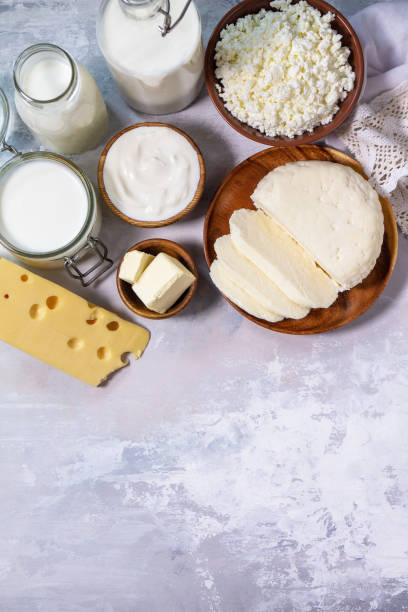 istock Set of different dairy products (milk, sour cream, cottage cheese, yogurt and butter) on a light stone countertop. Top view flat lay. Copy space. 1300865283