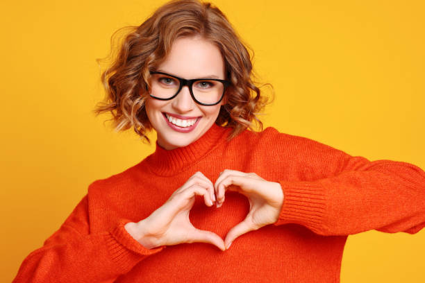 istock Happy young female gesturing heart 1300865745