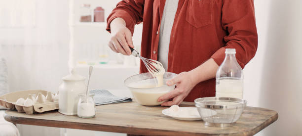 istock middle-aged man kneading pancake dough on white kitchen 1300869261