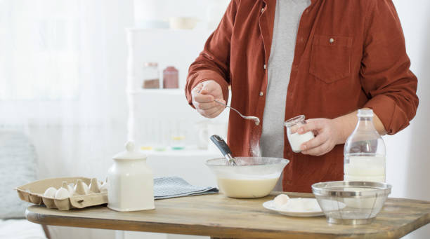istock middle-aged man kneading pancake dough on white kitchen 1300869264