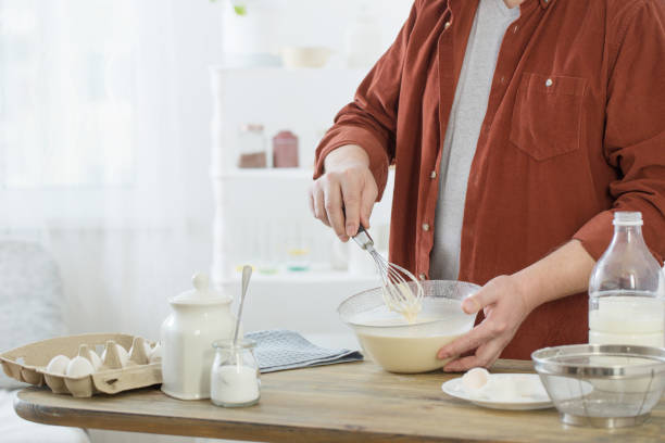 istock middle-aged man kneading pancake dough on white kitchen 1300869266
