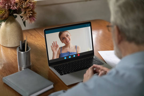 istock View from shoulder mature man making video call, watching webinar 1300870946