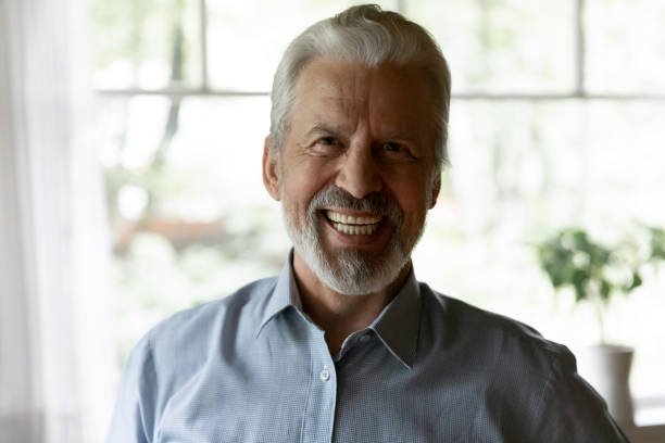 istock Close up laughing elderly grey haired man looking at camera 1300870961