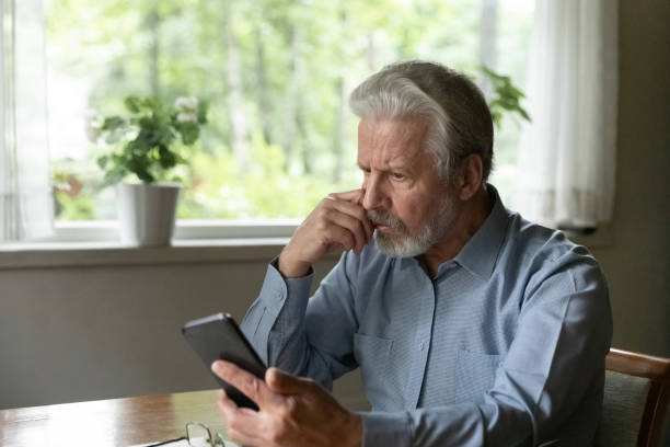 istock Close up stressed unhappy mature man looking at phone screen 1300870964