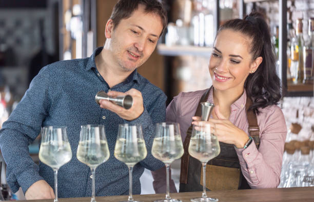istock Experienced bartender teaches apprentice the art of mixology, preparing cocktails on a bar. 1300871049