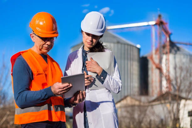 istock Employees with helmets and work clothes use a tablet outside 1300871869