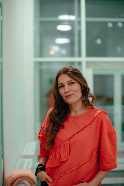 istock A lady in a red sweater poses against a glass wall. 1300872348