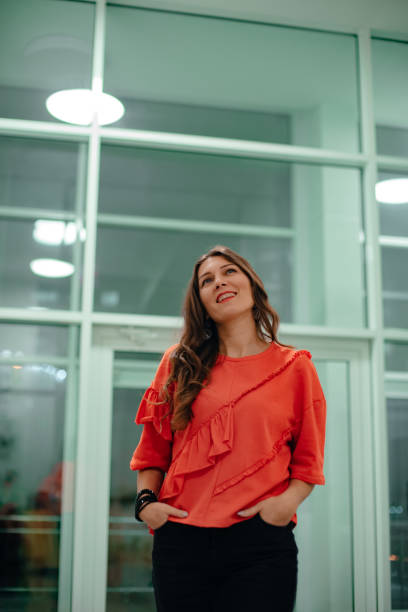 istock A lady in a red sweater poses against a glass wall. 1300872426