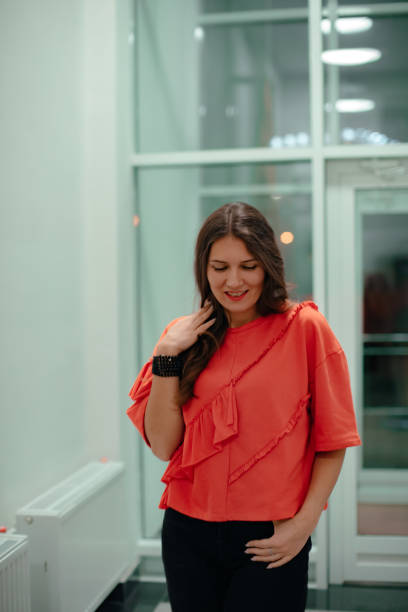 istock A lady in a red sweater poses against a glass wall. 1300872431