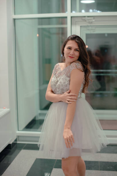 istock Lady posing in a white dress with rhinestones in the studio. 1300873375