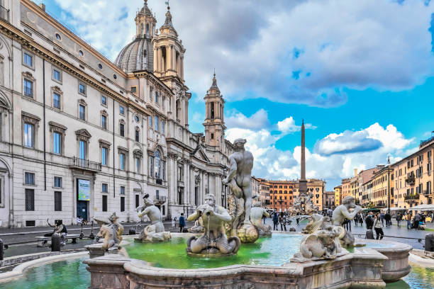 piazza navona with the mohrenbrunnen with dolphin sculpture and triton figures and the church of sant'agnese in agone in rome - piazza navona imagens e fotografias de stock